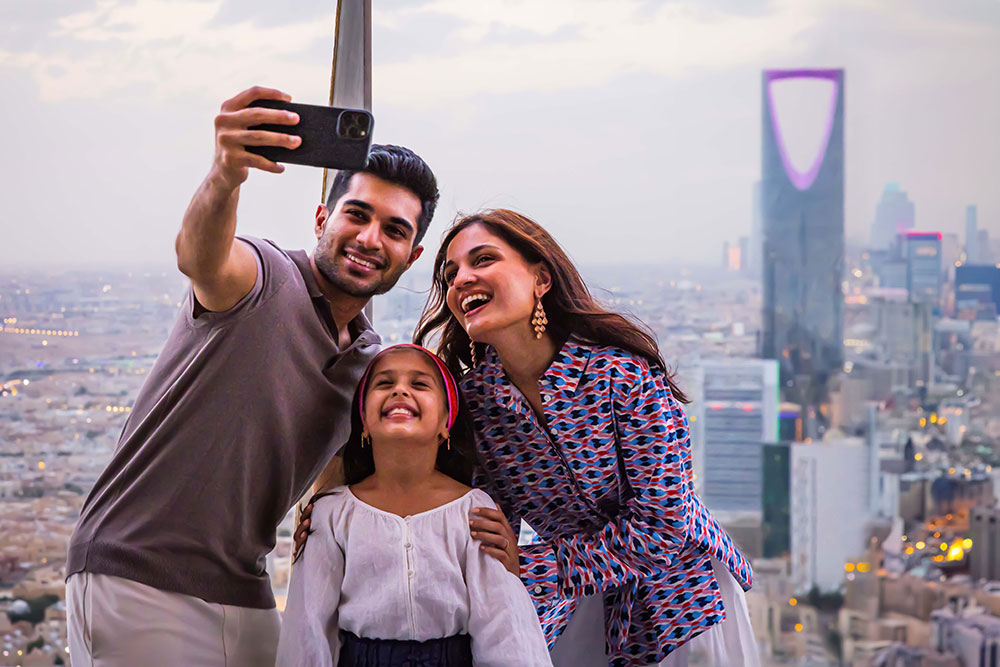 Family talking a selfi in front of the city of Riyadh