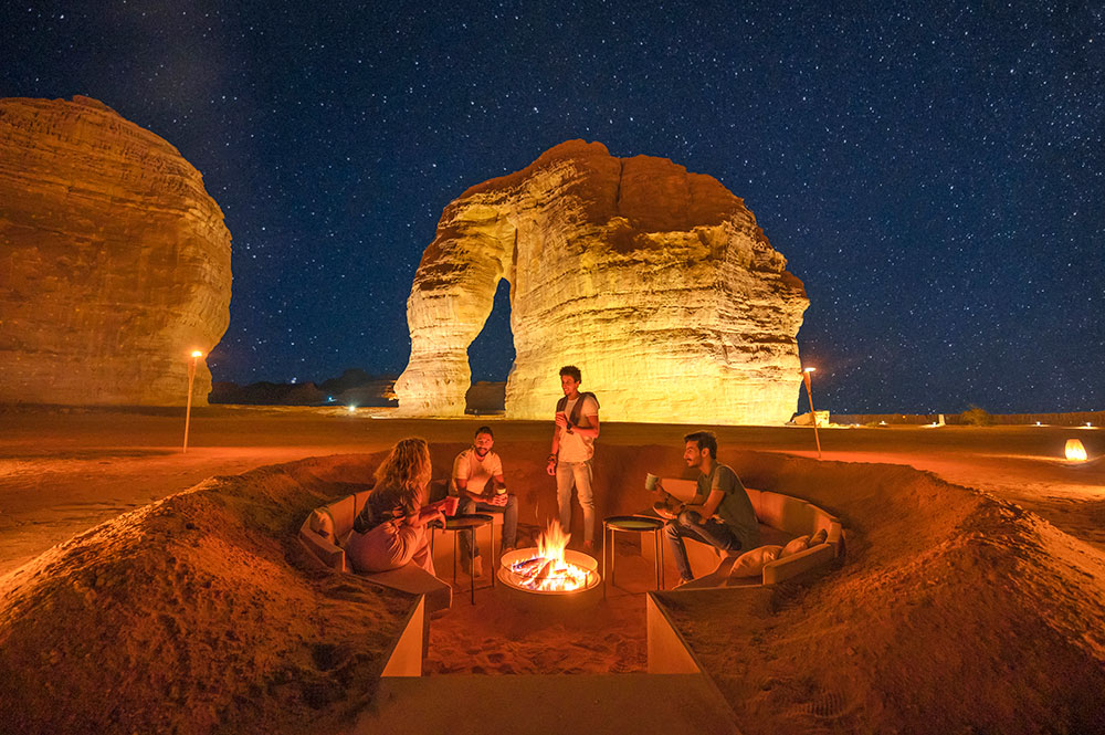 People having a barbaque in front of the elefant statue in AlUla at night.
